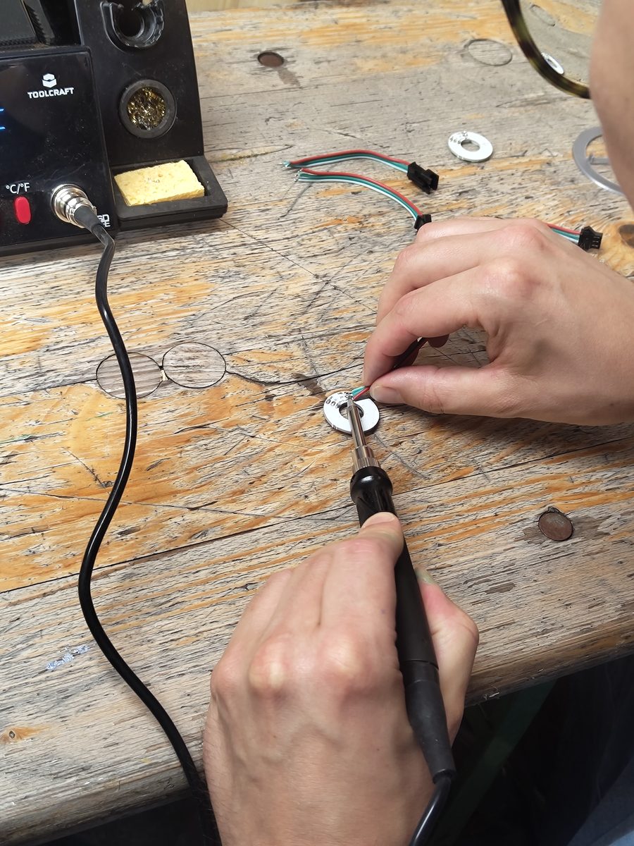 Teilnehmer lötet eine LED-Platine für seinen Leucht-Planeten